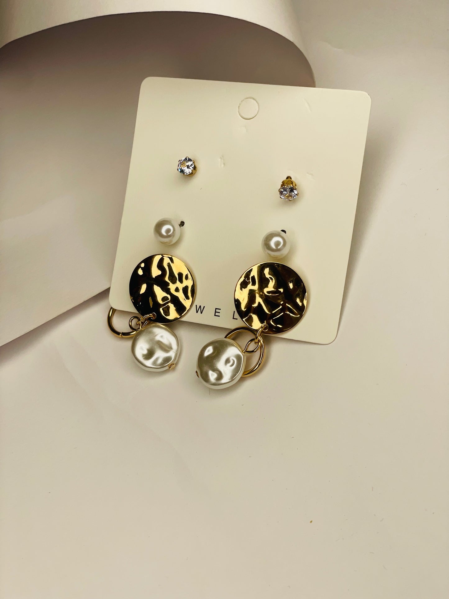 Pair of earrings on a display card with a plain background